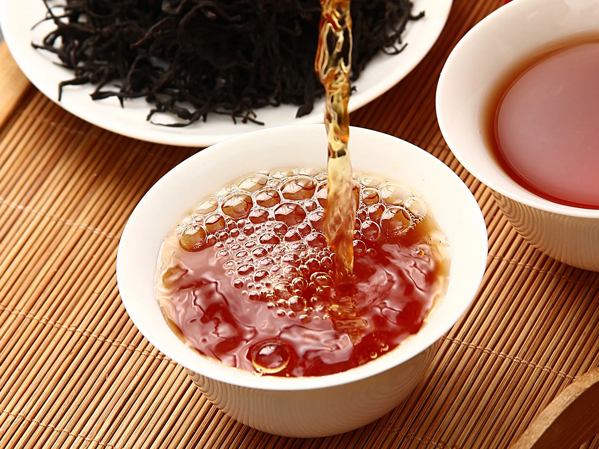 见山正山小种 · 茶汤倒入盖碗（透亮琥珀茶汤 + 干茶背景）